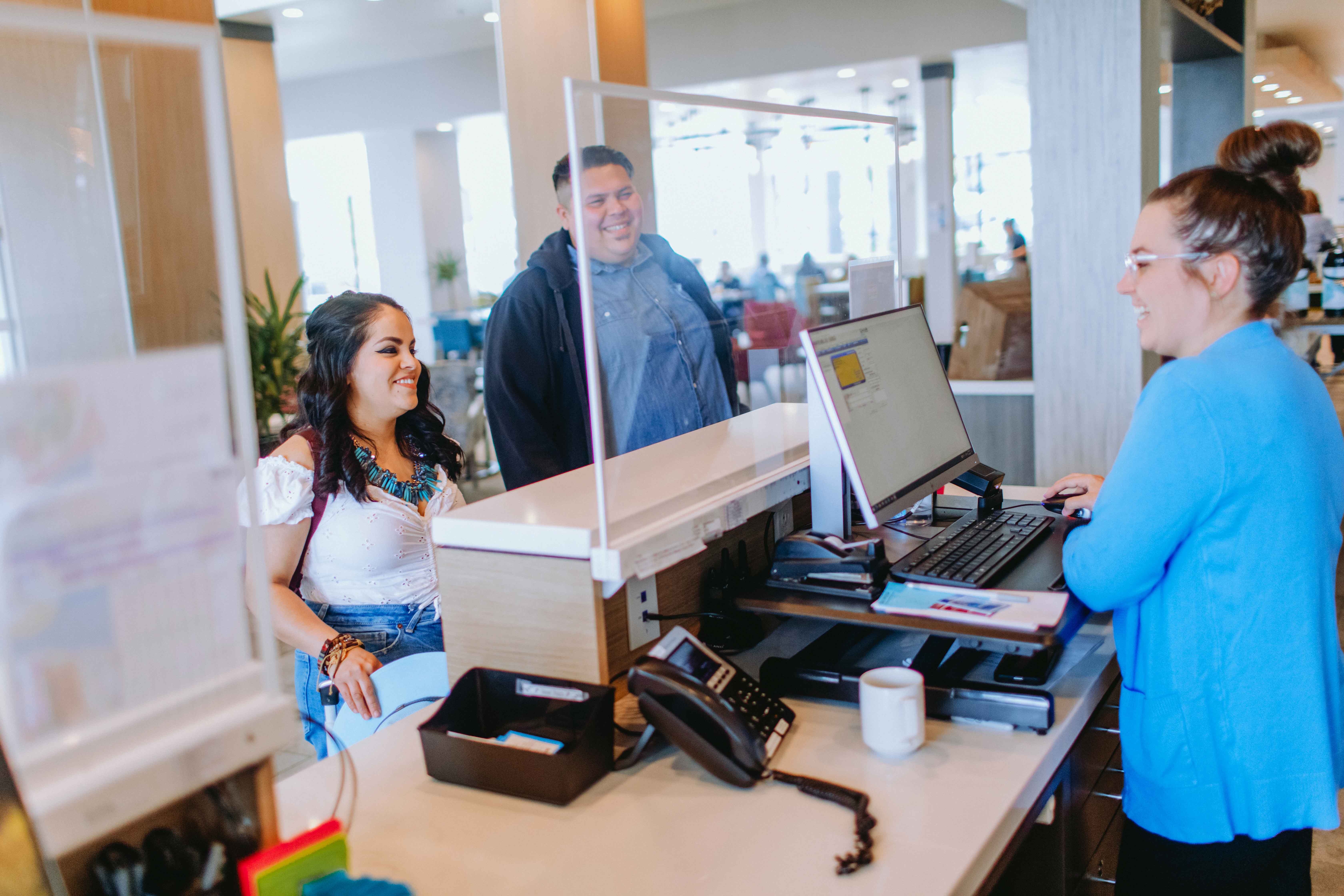 Couple interacting with a worker behind a computer